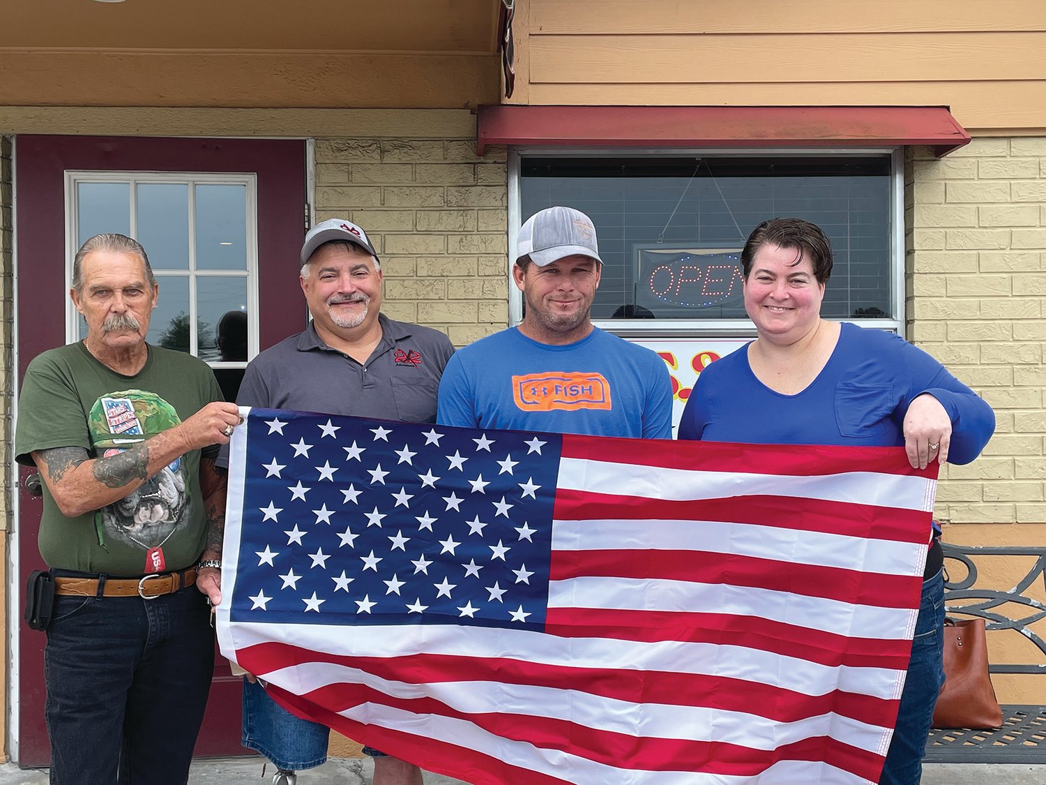 OKEECHOBEE – Jonica Hough (right), owner of Ultimate Flags Inc. donated flags to veterans Ronnie Rhoads, Steve Cone, Gregg Maynard (left to right) and several others not pictured. “Thank you for your service,” said Jonica and Glenn Hough. “It was the least we could do for those who served.”